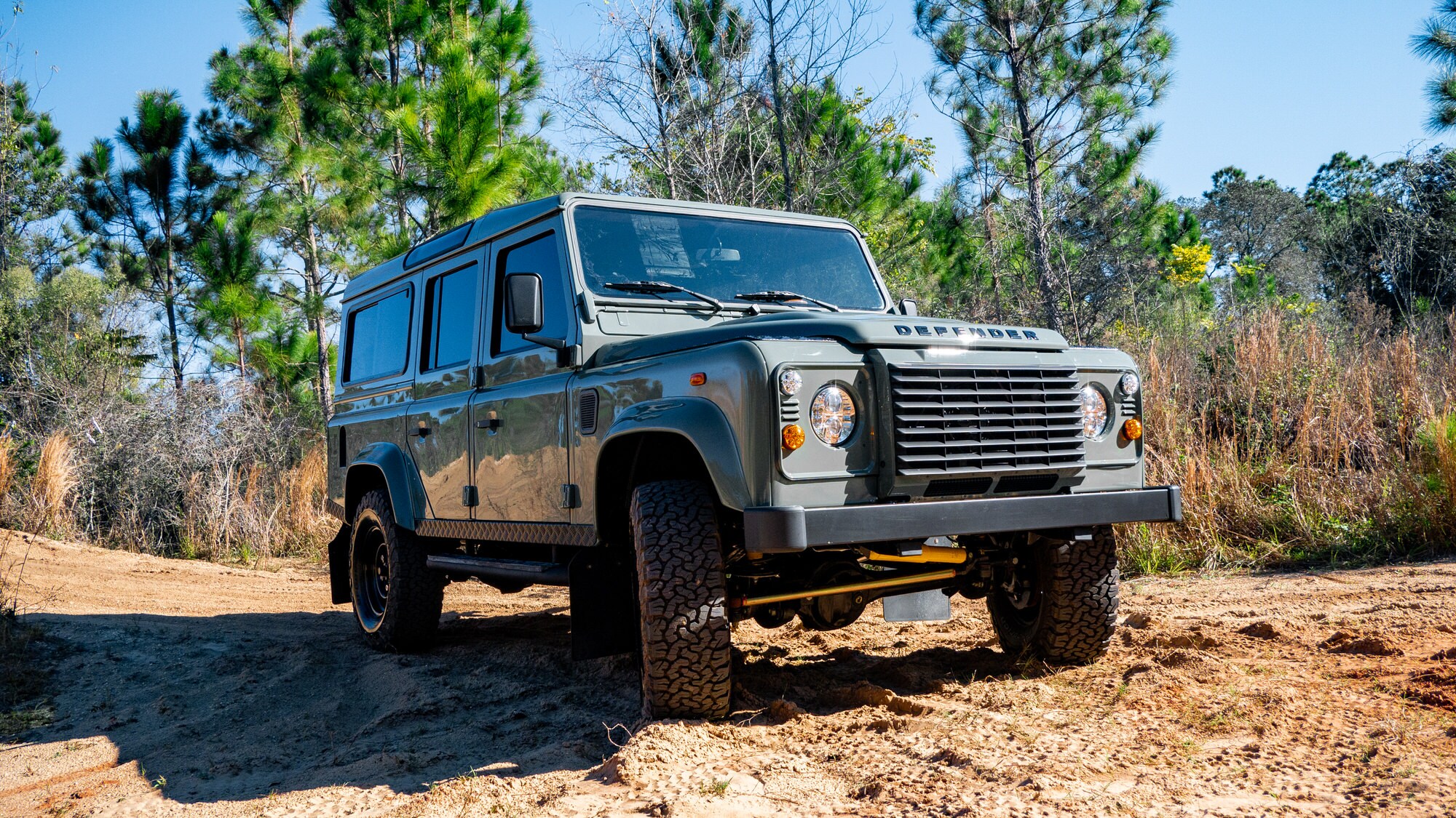 Profile pic of the classic land rover defender on a dirt road