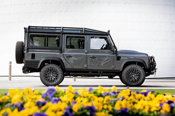 custom defender 110 behind a flowerbed